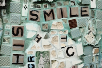 Close-up of a handcrafted mosaic art piece made from colorful broken pottery, sea glass, and smooth pebbles.