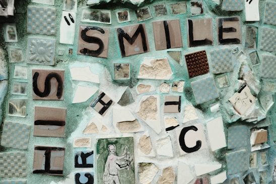Close-up of a handcrafted mosaic art piece made from colorful broken pottery, sea glass, and smooth pebbles.