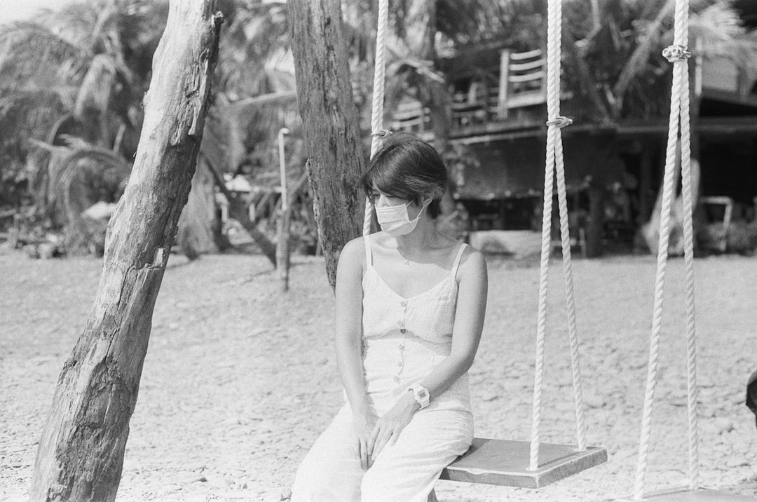 woman in white spaghetti strap top sitting on swing