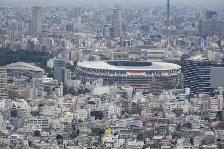 An image of Tokyo taken during the Olympics. A TOKYO 2020 banner hangs outside a stadium.