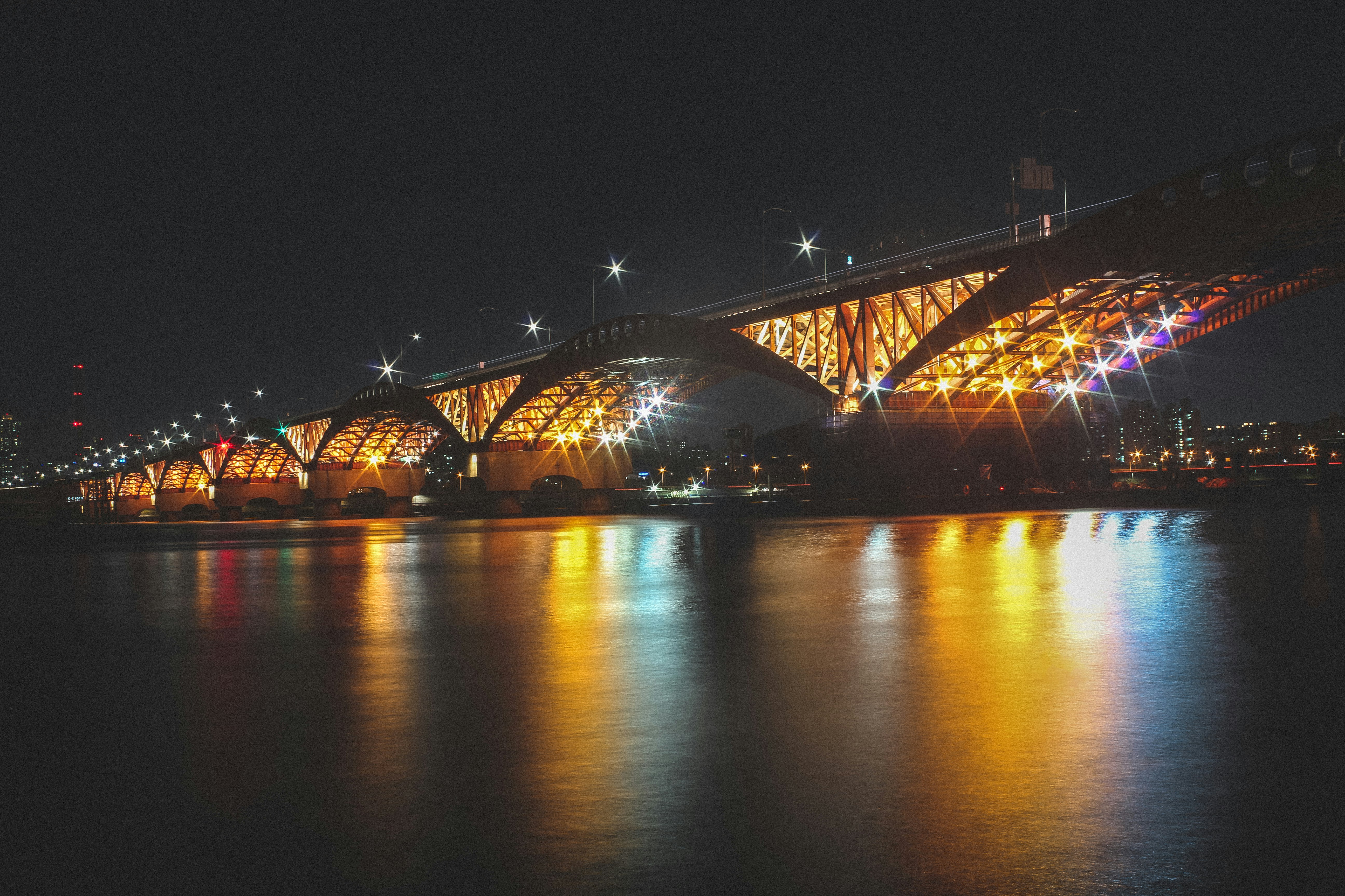 lighted bridge over water during night time