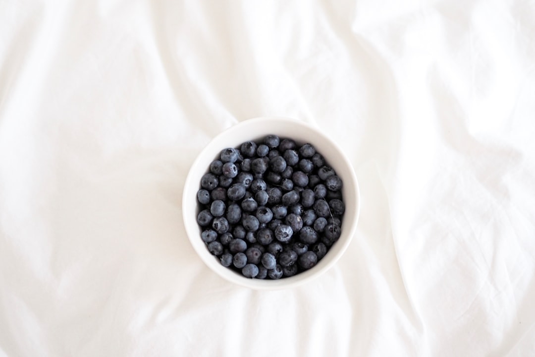 black round fruits on white ceramic bowl