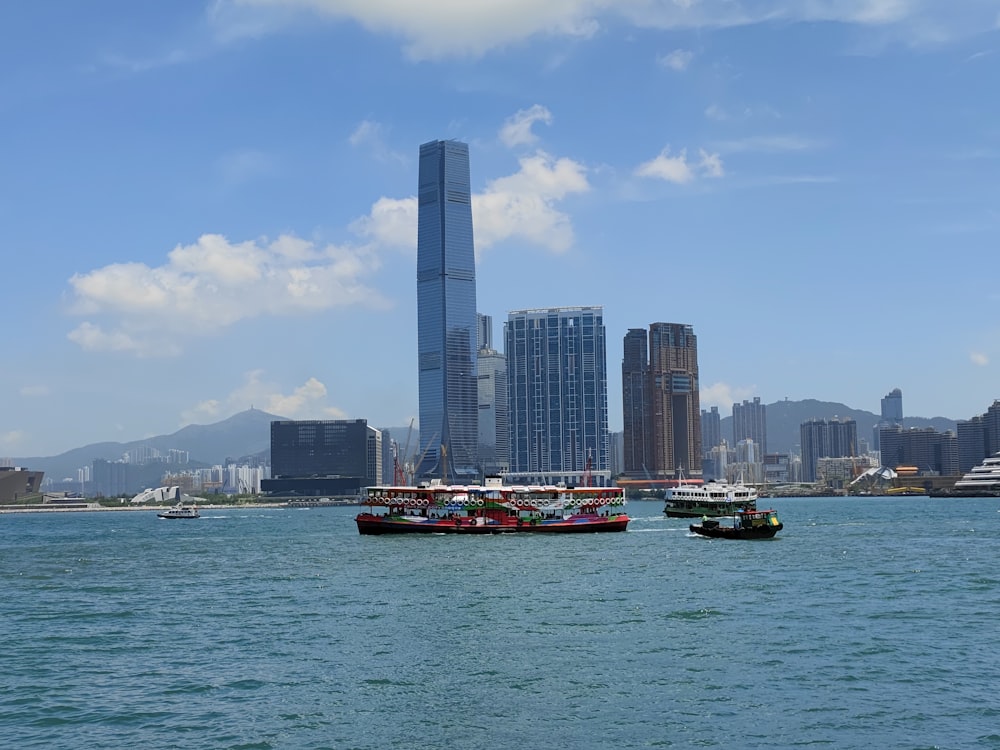 red and white boat on sea near city buildings during daytime