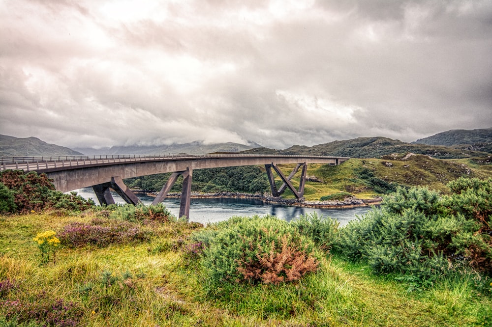 brown wooden bridge over river under cloudy sky during daytime