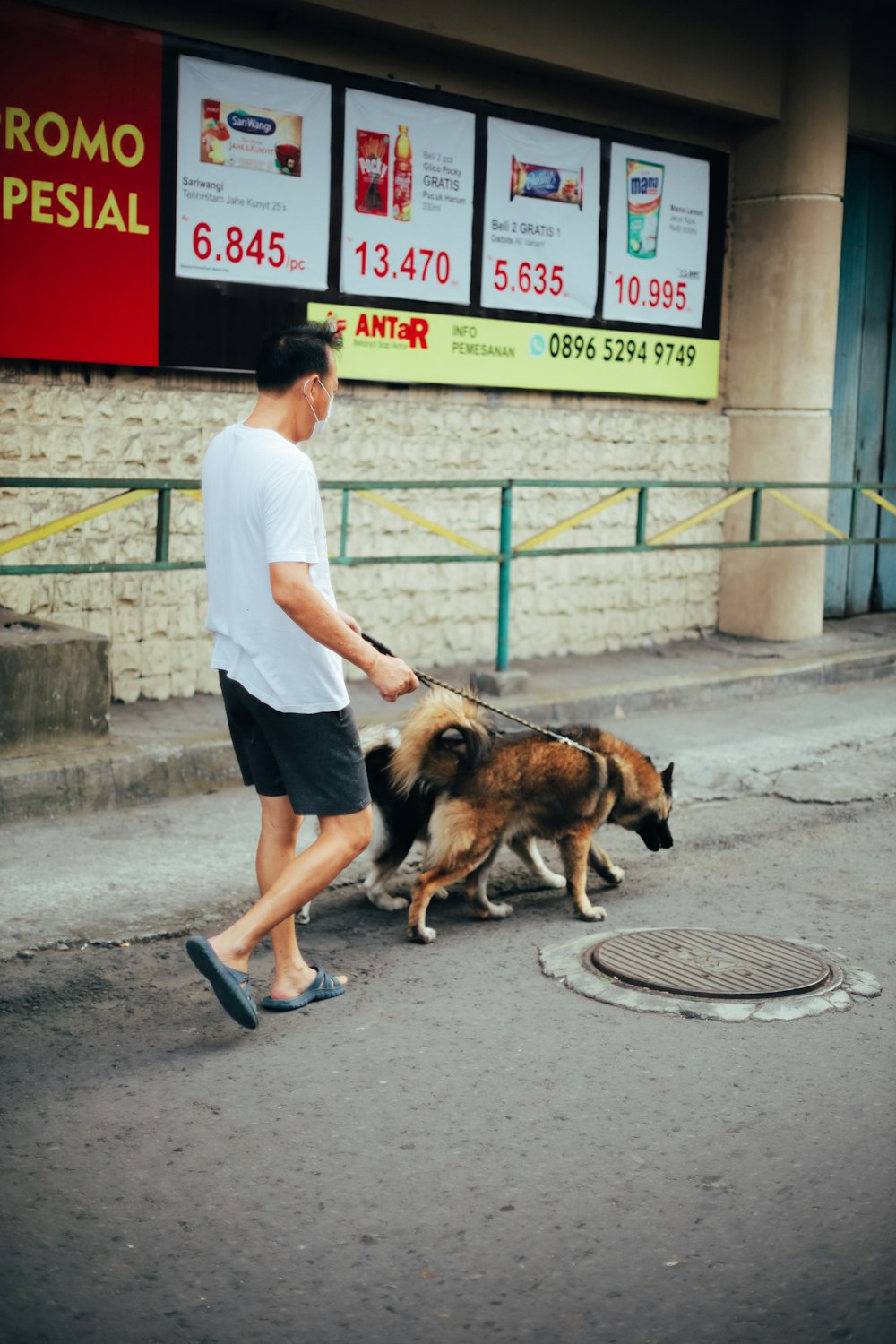 man in white dress shirt and black pants holding brown and black dog