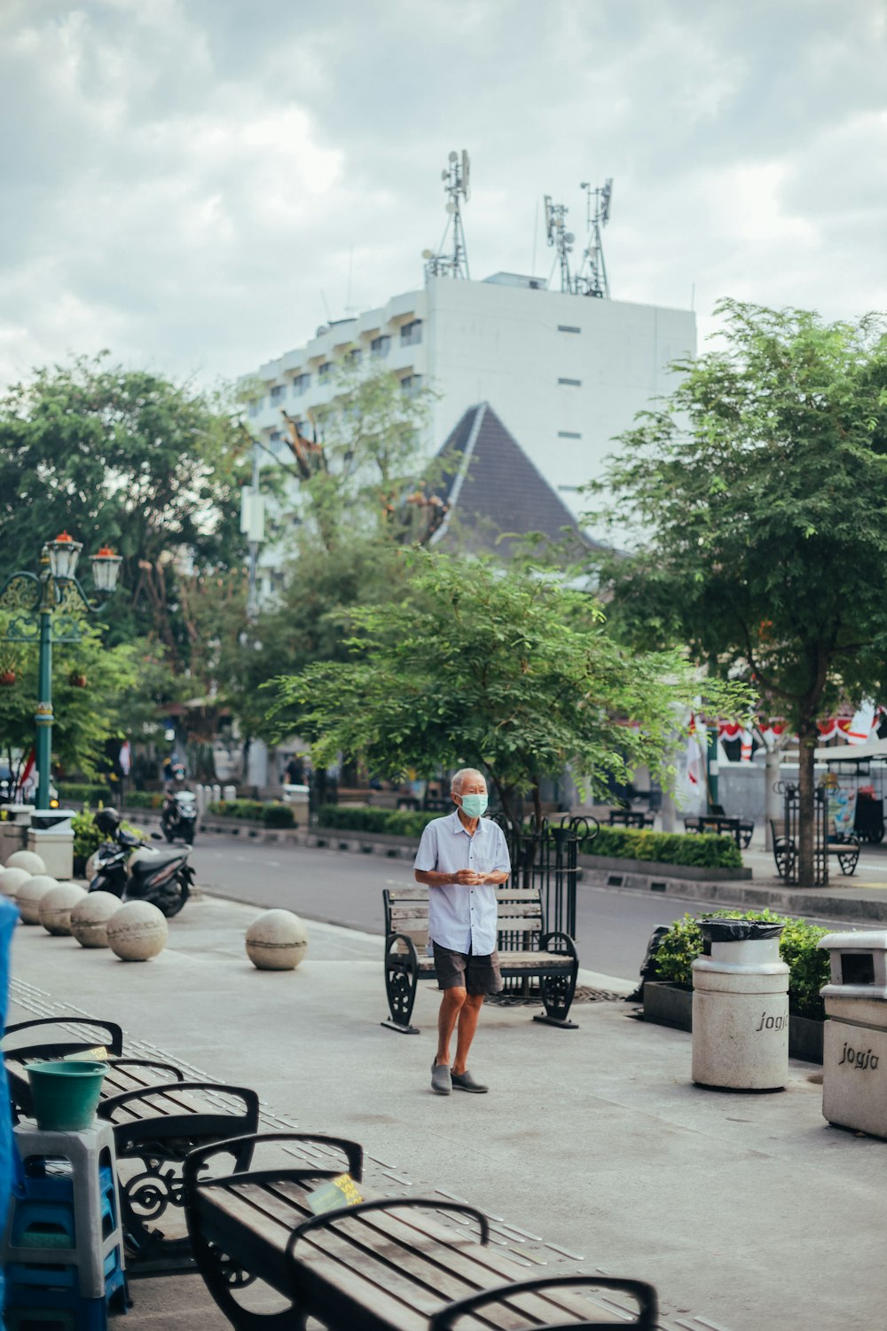 man in white t-shirt and black shorts walking on street during daytime