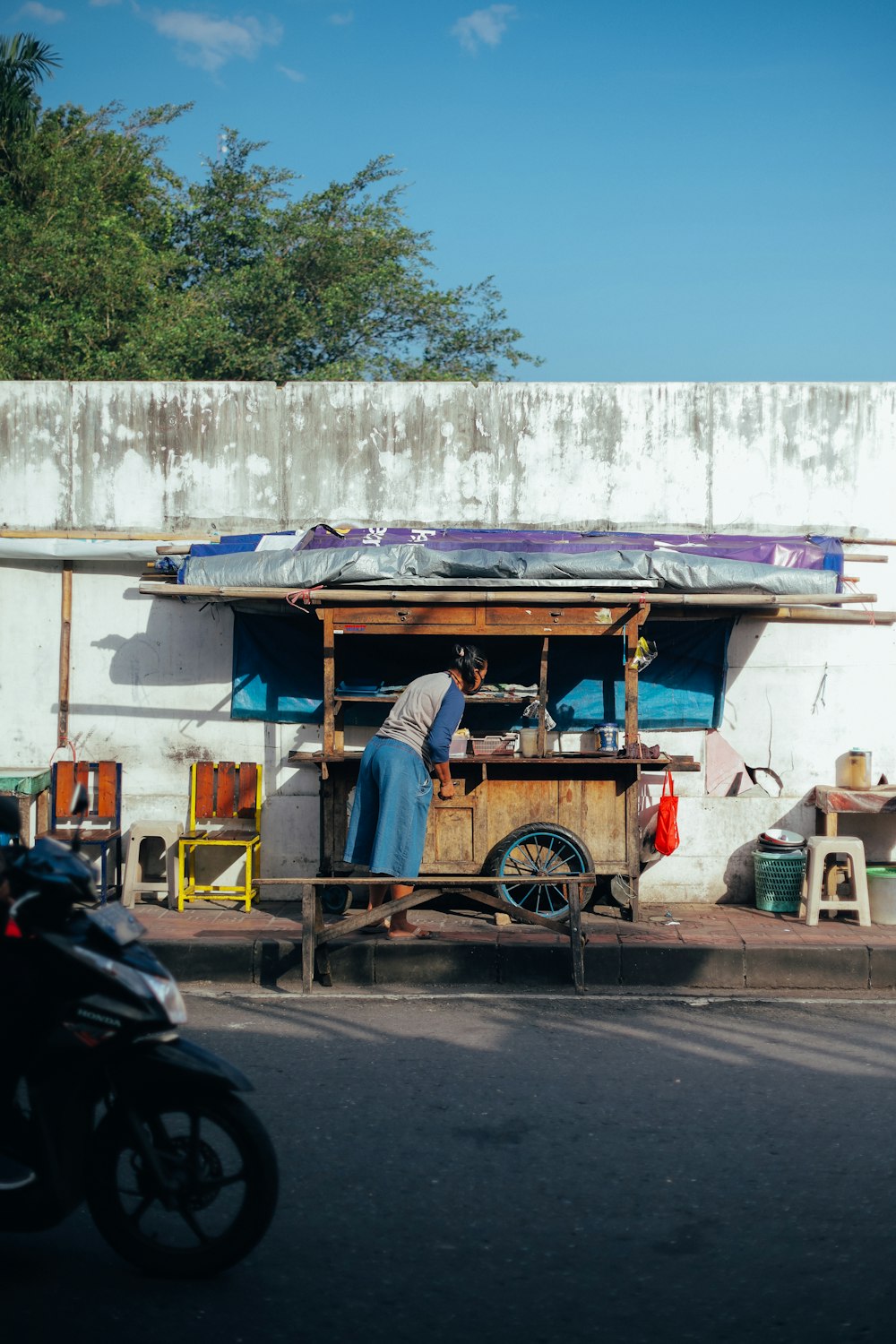 Un hombre parado frente a un carrito de comida