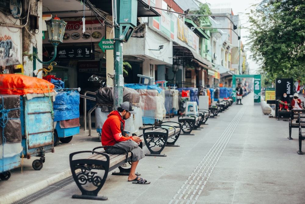 a man sitting on a bench in front of a store