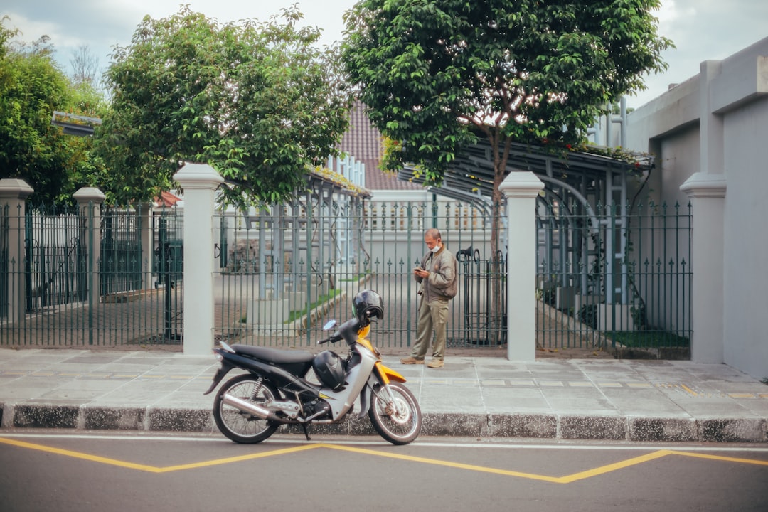 man in brown jacket riding motorcycle on road during daytime