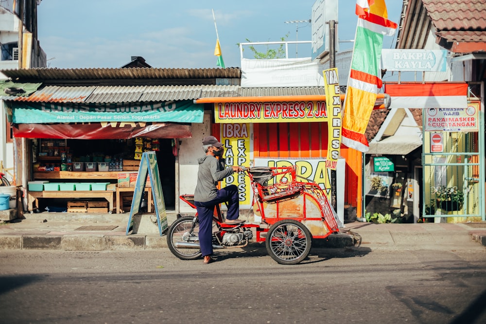 man in blue shirt riding on red and black motorcycle during daytime