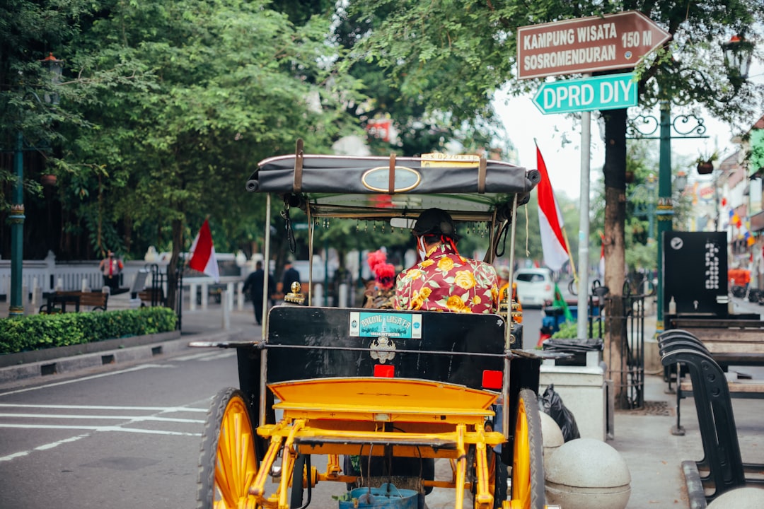 2 men riding on yellow and black auto rickshaw on road during daytime