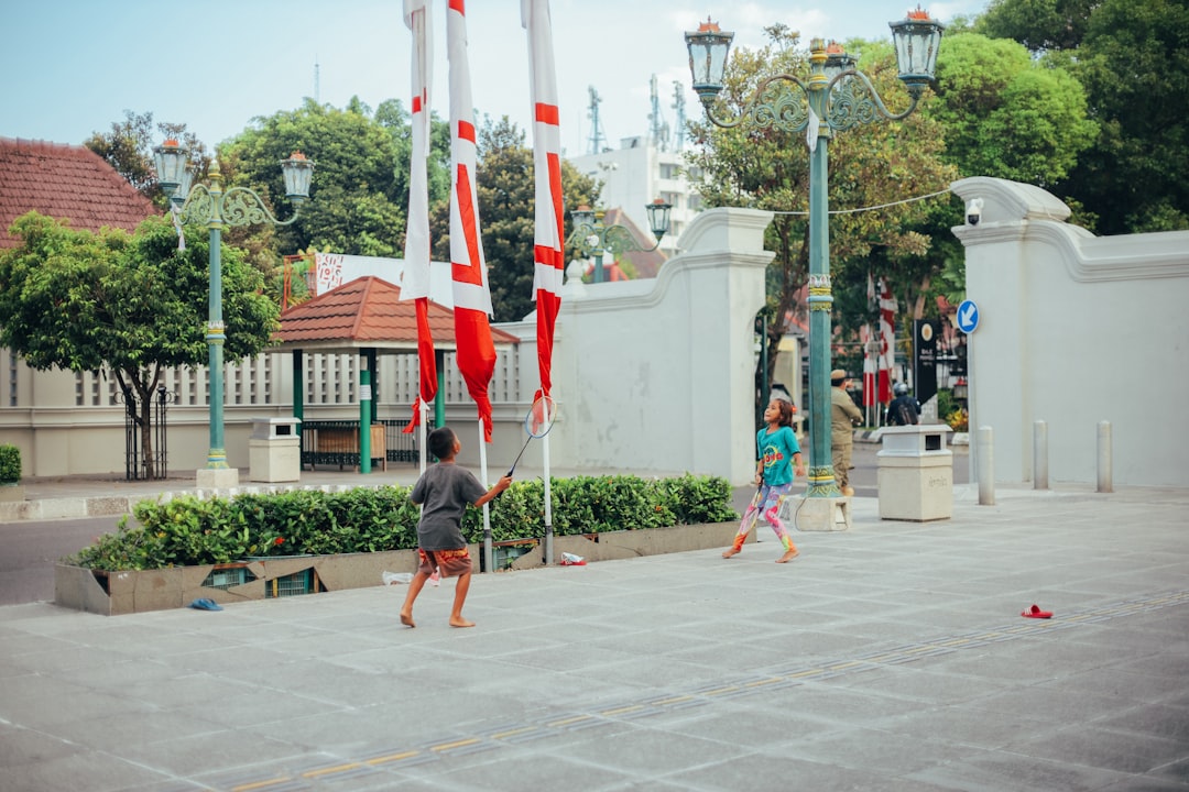 man in black t-shirt and red shorts holding flag of us a during daytime