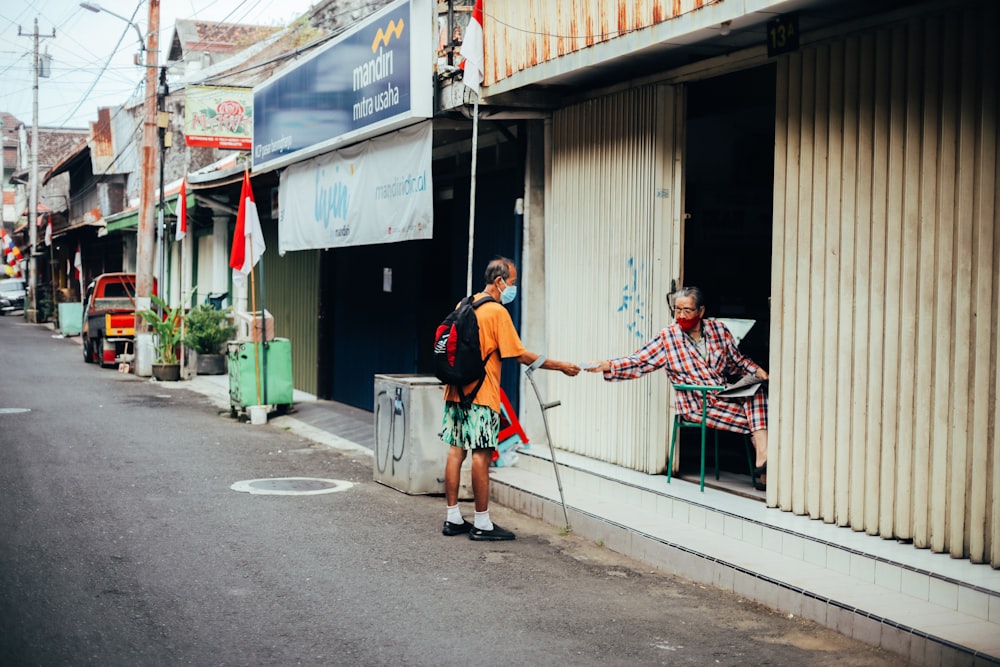 man in red shirt and woman in blue t-shirt walking on sidewalk during daytime