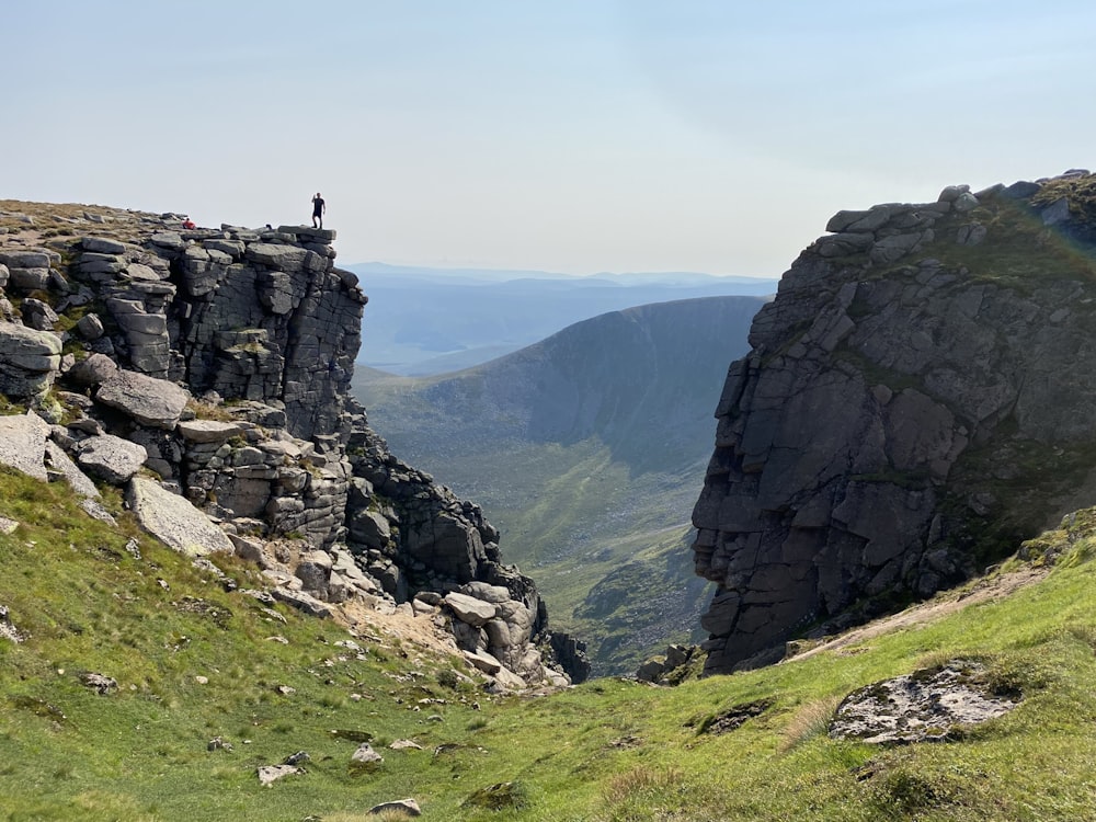 campo di erba verde vicino alla formazione rocciosa grigia durante il giorno