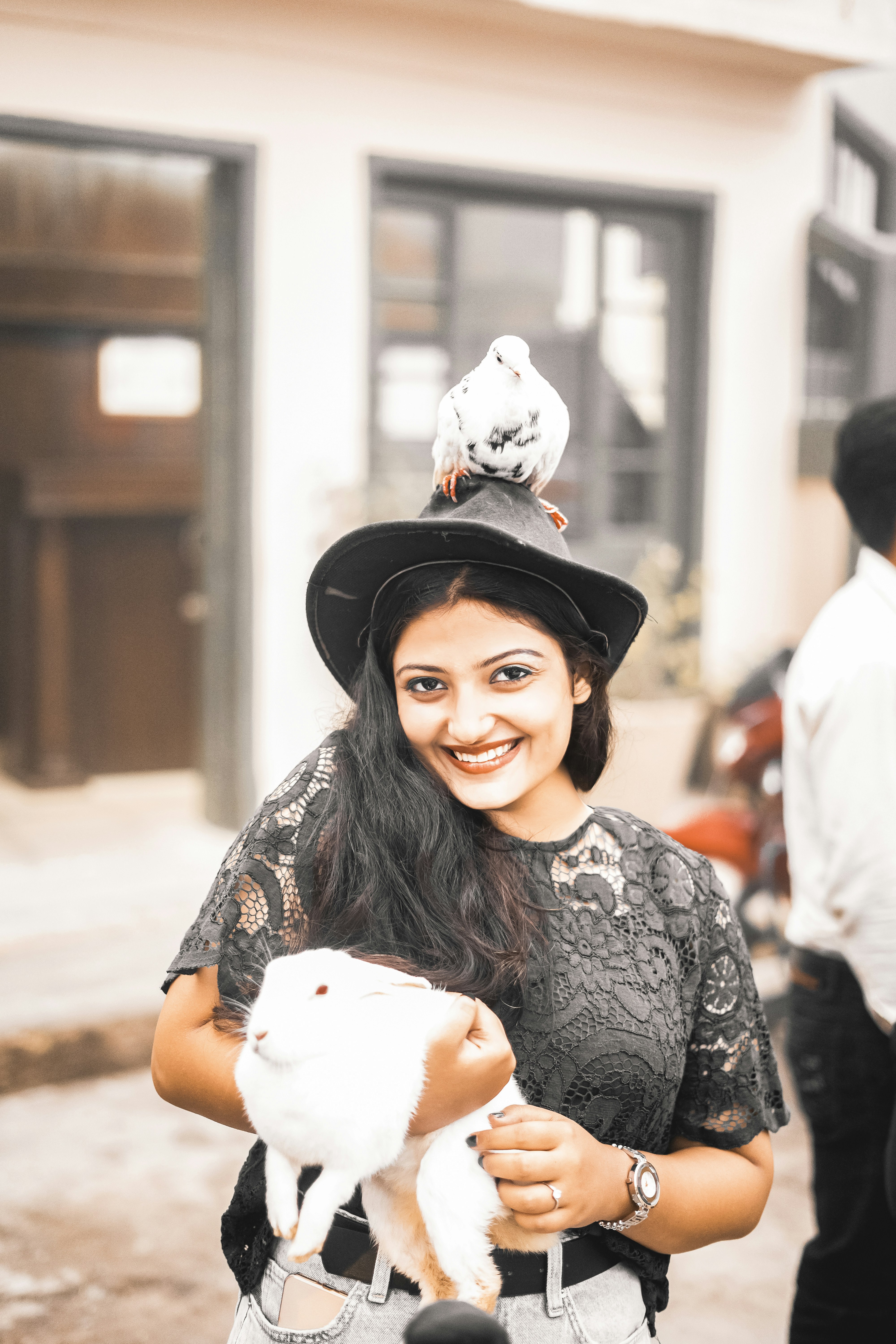 Frau in schwarzem Hut und schwarz-weißem Blumenkleid