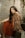 woman in red and gold sari dress sitting on gray concrete stairs