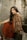 woman in red and gold sari dress sitting on gray concrete stairs