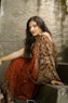 woman in red and gold sari dress sitting on gray concrete stairs