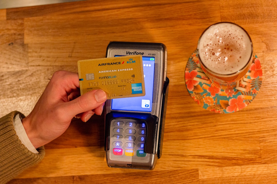 person holding black android smartphone, Paying with American Express for a Beer