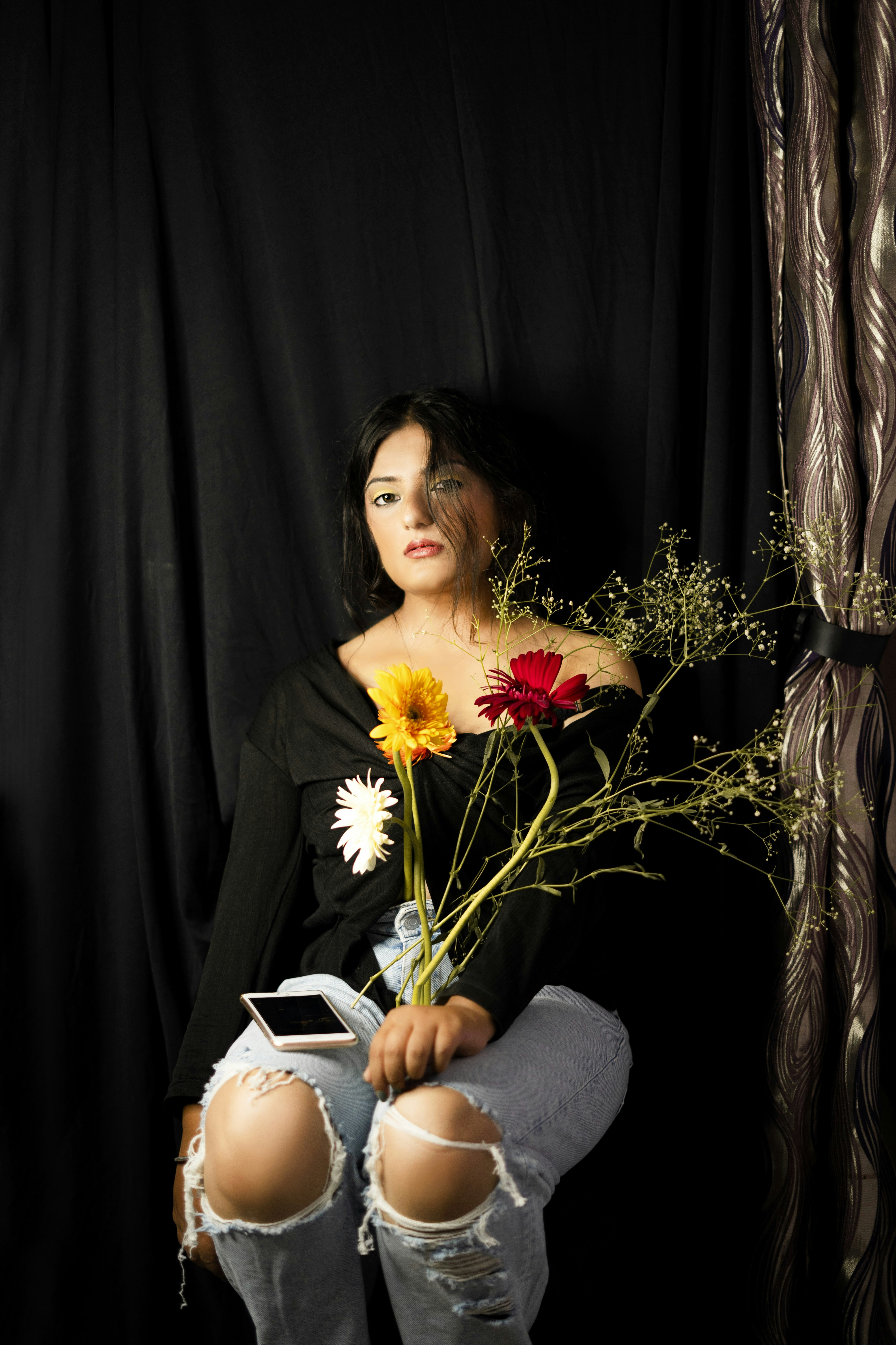 Frau im schwarzen Langarmhemd mit weißen und gelben Blumen