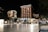 A well-lit hotel complex at night with prominent signage for Grand Hotel Portorož and Hotel Neptun. The buildings are illuminated with warm lights, and cars are parked in front of the hotel. Several people are visible, some seated and others walking by, under a clear night sky.