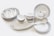 A set of neatly arranged ceramic tableware, consisting of plates, bowls, saucers, and spoons. The dishes are predominantly white with subtle gold and silver decorative bands around their edges. The bowls are stacked in varying sizes and the plates are similarly organized. Two small cups are placed inside a large bowl.