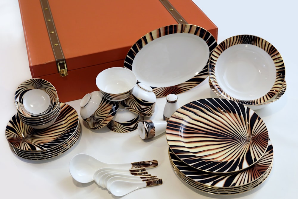 white and black ceramic plates on brown wooden table