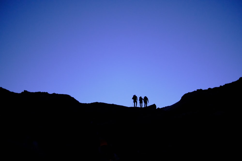 silhouette of people on top of mountain during sunset