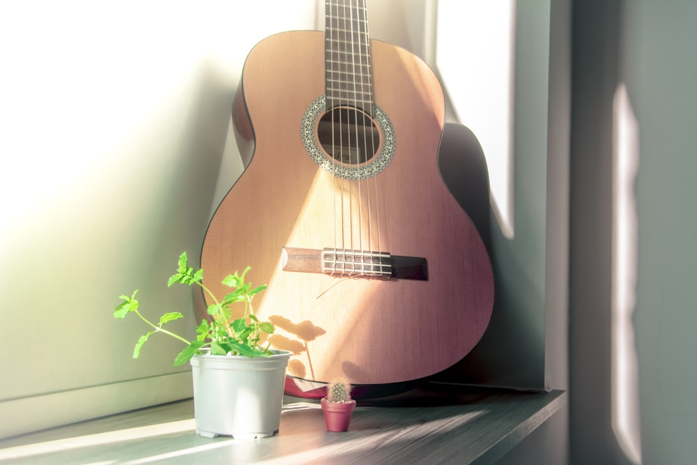 Guitarra acústica marrón sobre mesa de madera marrón