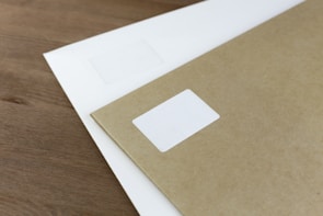 Image showing a stack of malote envelopes ready for delivery on a wooden desk.