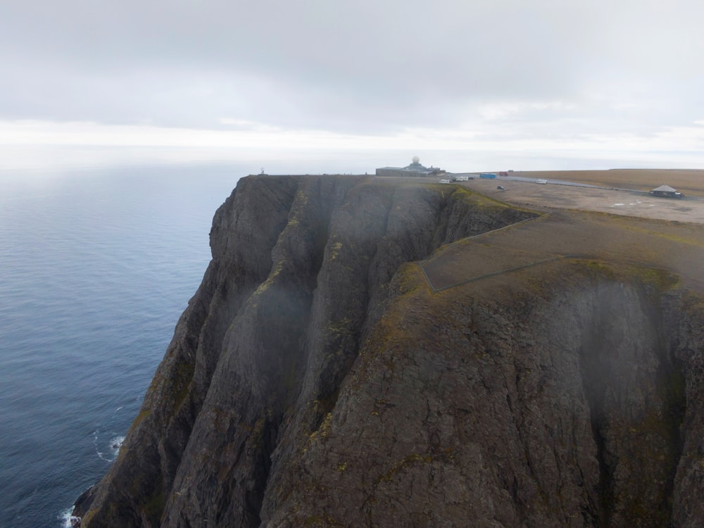 green and brown mountain beside sea under white sky during daytime