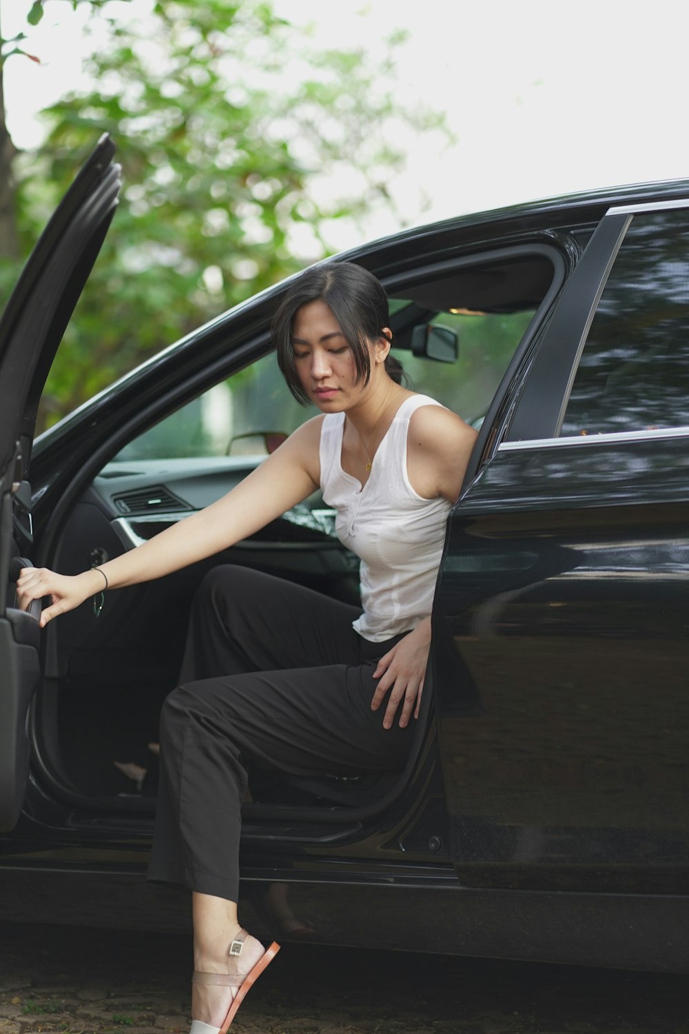 a woman sitting in the open door of a car