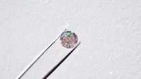 Close-up of a jeweler carefully examining a sparkling diamond under bright lights.