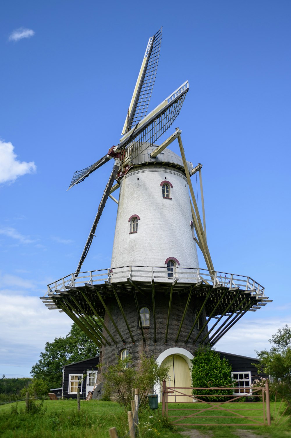 weiße und schwarze Windmühle unter blauem Himmel tagsüber