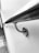 A sleek, metallic handrail is attached to a smooth white wall, with a reflective surface and curved design. The perspective is diagonal, creating a dynamic and modern feel.