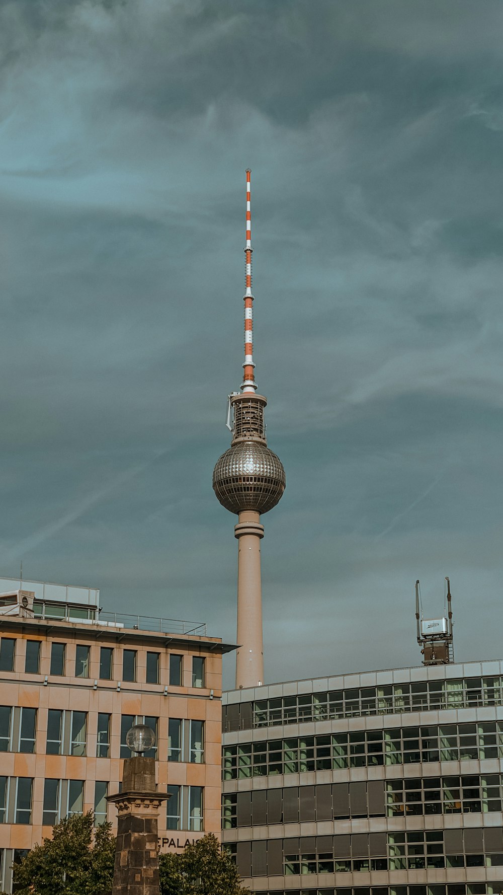 white and red tower under cloudy sky