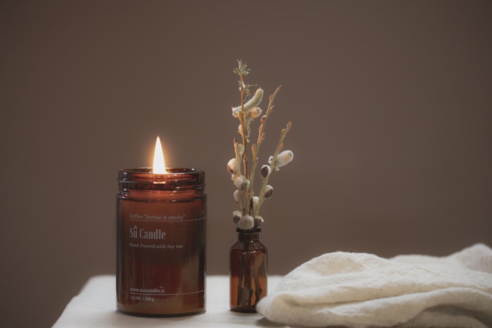 brown pillar candle on brown glass bottle