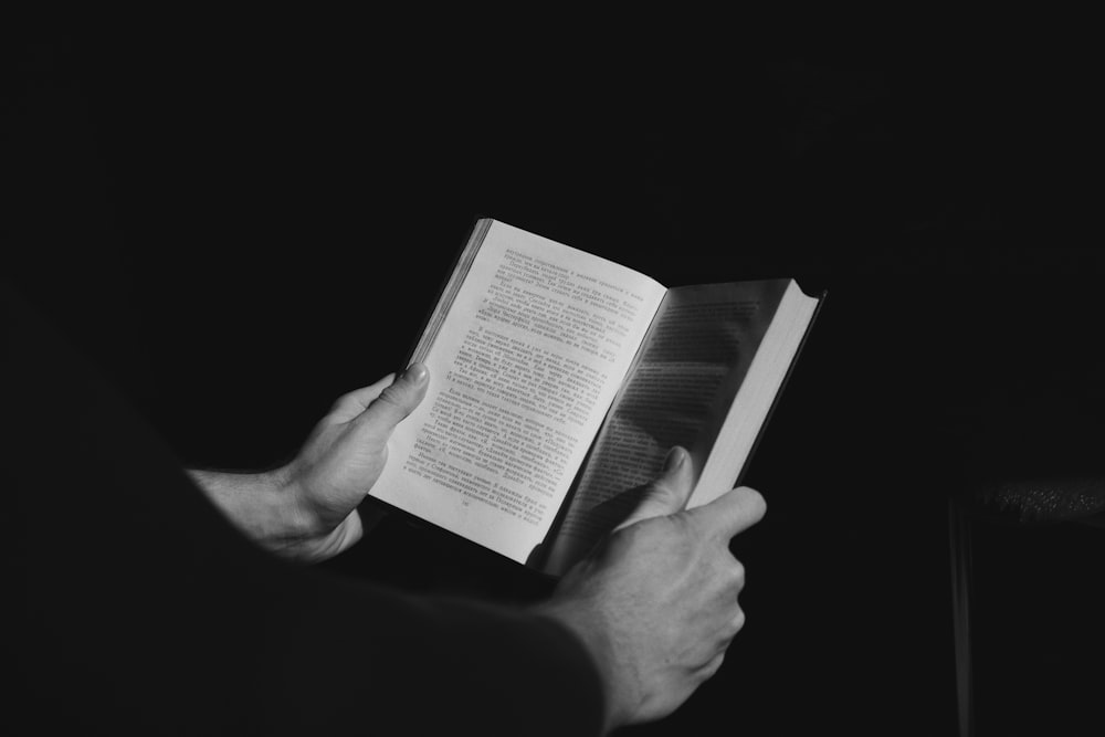 grayscale photo of person reading book