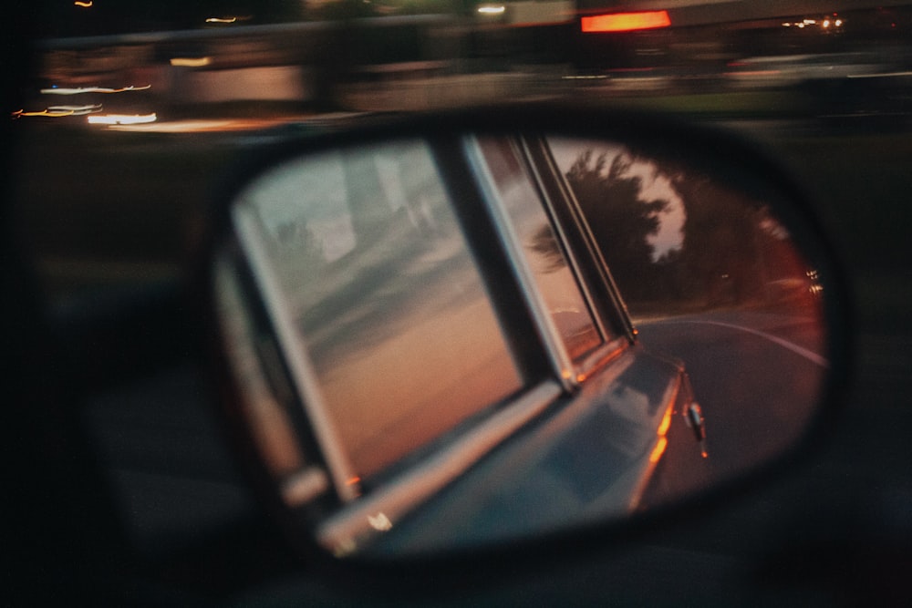 black car side mirror showing red light