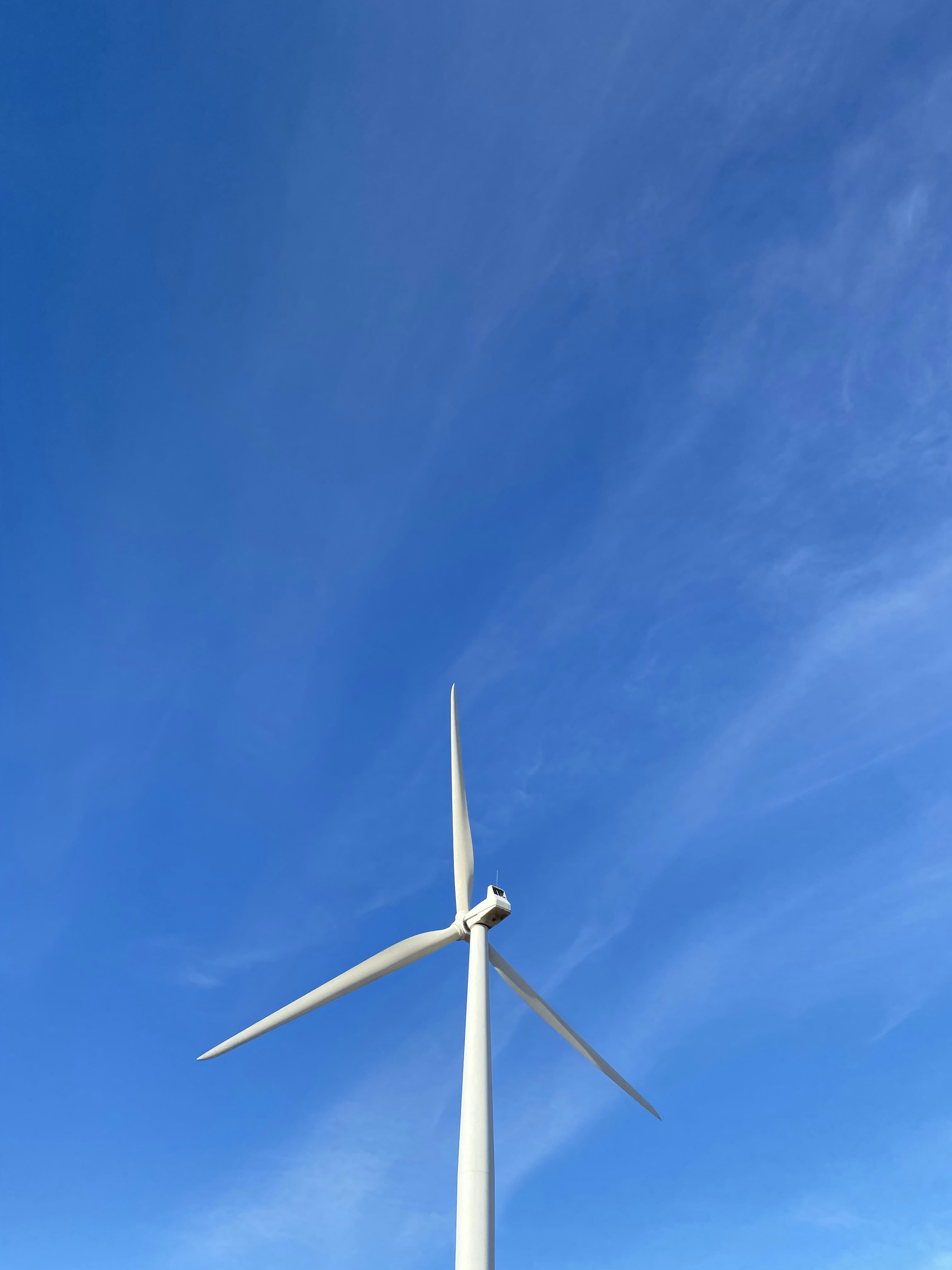 white wind turbine under blue sky during daytime