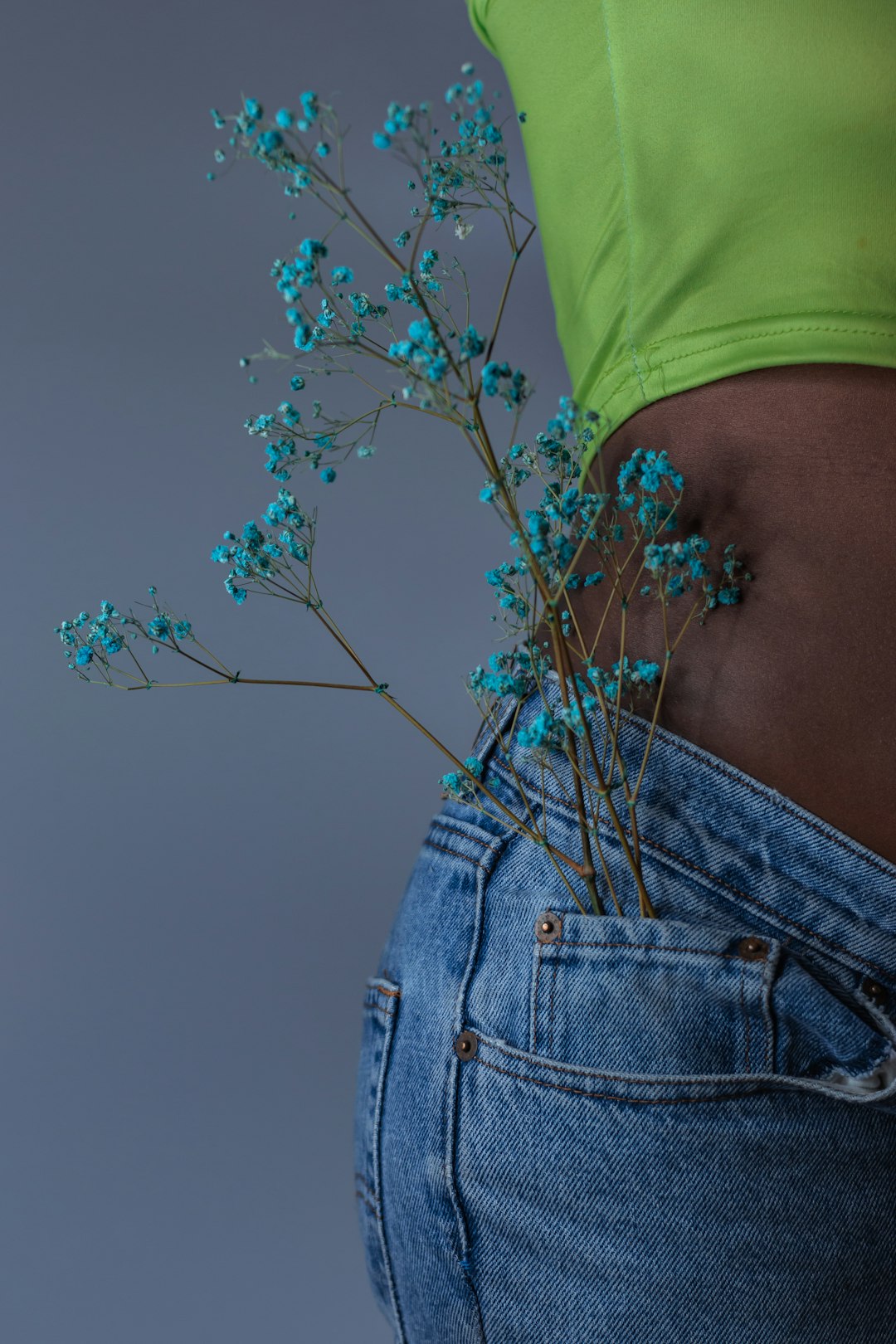 person in green shirt and blue denim jeans