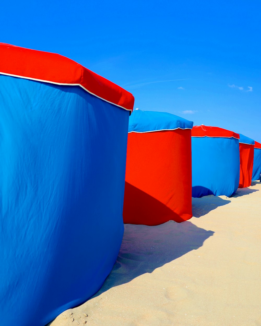 blue and red inflatable tent on brown sand during daytime