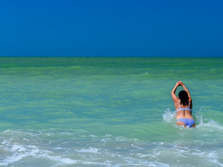 woman in blue and white bikini top on water during daytime