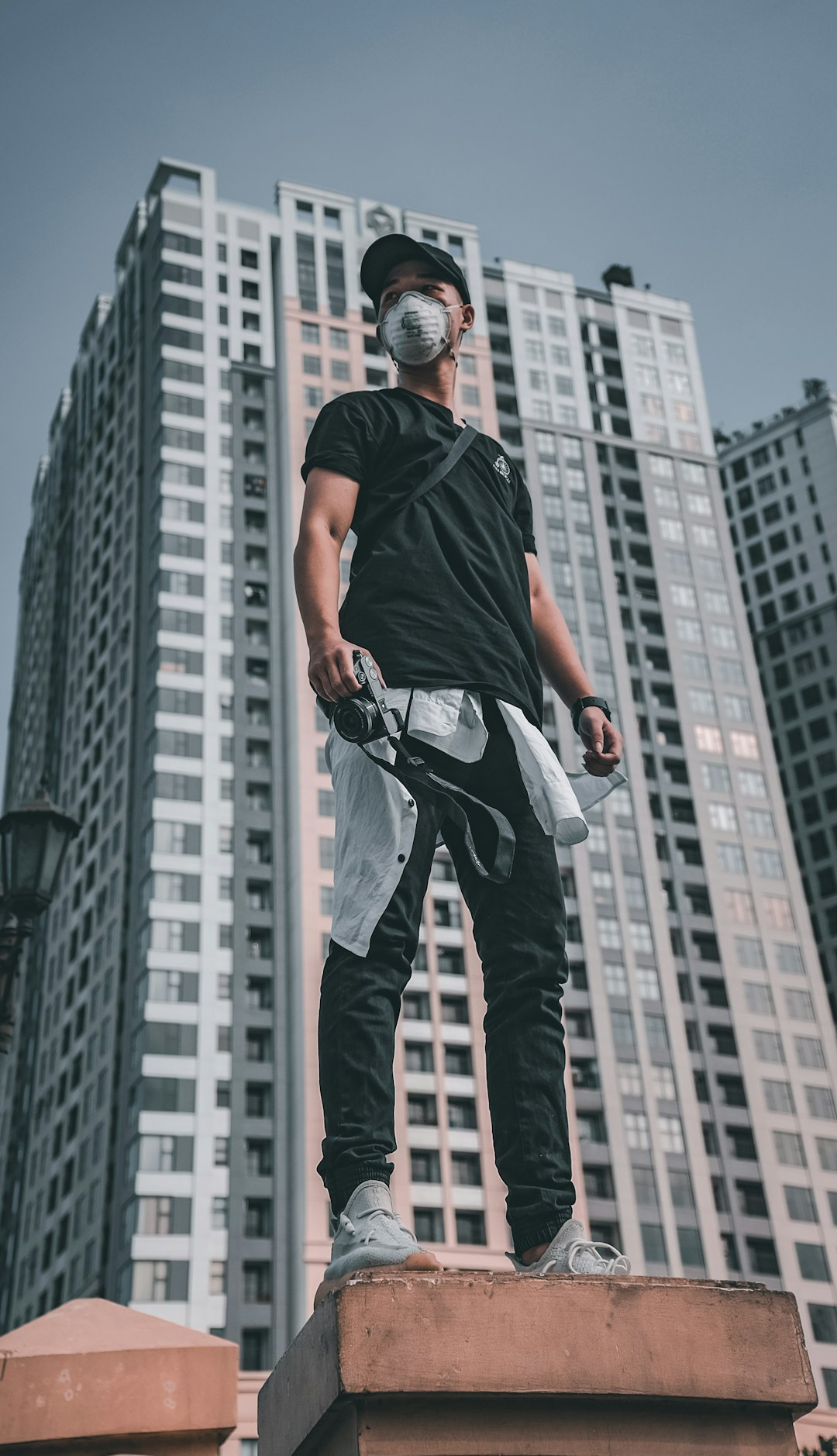 man in black t-shirt and blue denim jeans with black backpack standing on the ground