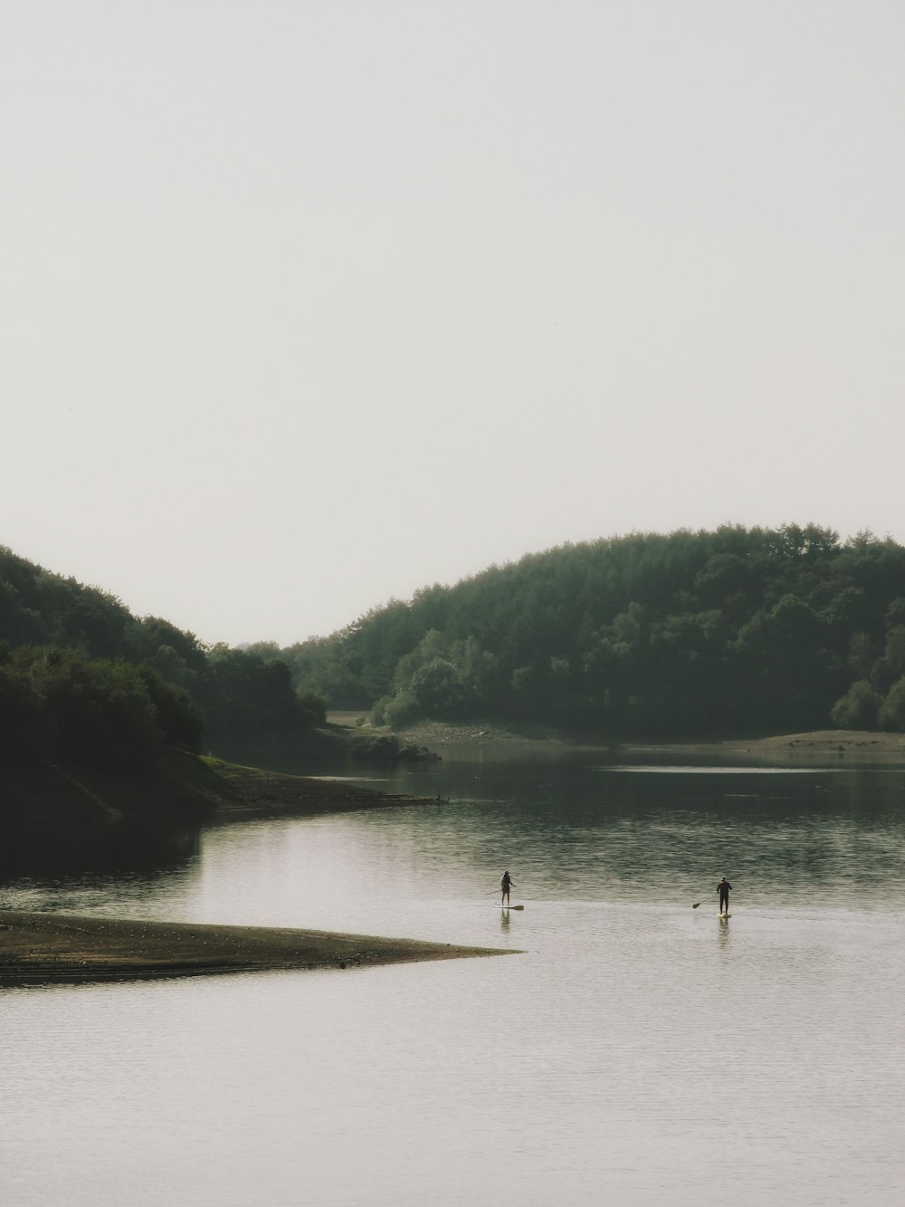 people riding on boat on lake during foggy weather