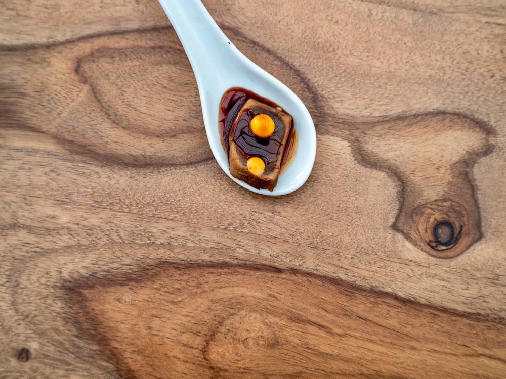 white plastic spoon on brown wooden table