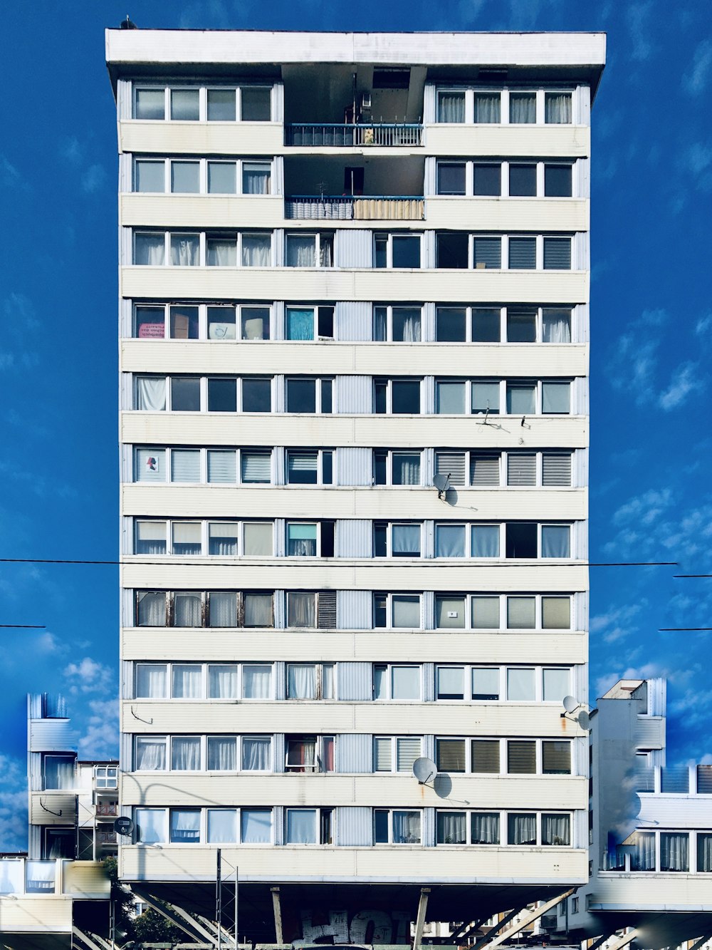 낮 동안 푸른 하늘 아래 흰색 콘크리트 건물