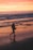 woman walking on beach during sunset