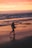 woman walking on beach during sunset