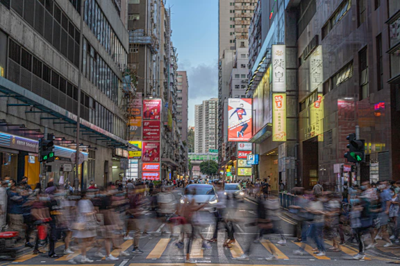 cars on road between high rise buildings during daytime